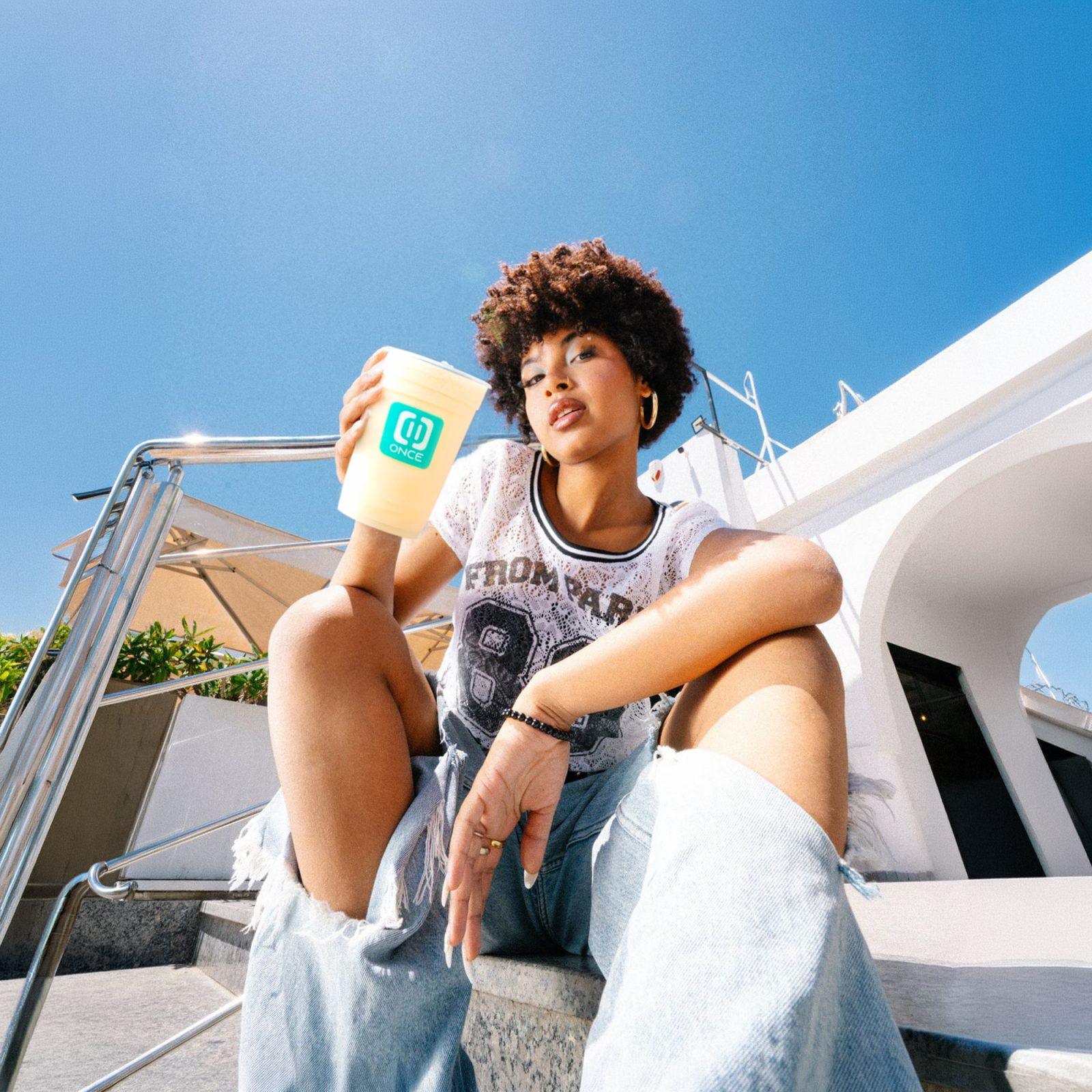 Fotomontaje publicitario en Iquique para Once Tea House con modelo lifestyle sosteniendo vaso de la marca